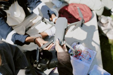 Tanınamayan kızların grafit drone 'la el ele tutuşup, onu tamir ederken yüksek açılı çekimleri.