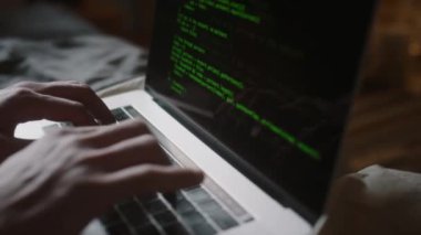 Yatak odasındaki modern dizüstü bilgisayarda tanımlanamayan erkek programcının ellerine yakından bakın.