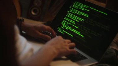 Evdeki dizüstü bilgisayarı kullanarak uygulama için kod yazan bilinmeyen erkek geliştiricinin ellerinin yakın görüntüsü