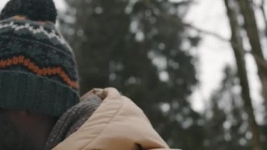 Yakından bakınca, genç bir babanın kış ormanlarında yürürken genç kızını kar kızağına bindirişini görüyorum.