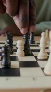 Satranç oynarken rakiplerini fille birlikte rehin alan tanınmayan siyahi adamın dikey yakın çekimi