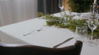 Evdeki Noel yemeğine hazırlanırken masaya boynuz halkasıyla süslenmiş peçeteyle tabağı yerleştiren kadının ellerini kapat.