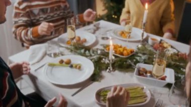 Aile fertlerinin geleneksel ev kutlamalarında Noel yemeğinden önce el ele tutuşup dua etmelerine yakından bakın.