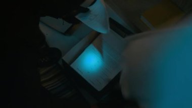 Bilinmeyen hırsız kutusunu açıp belgeleri karıştırırken, dolar banknotları bulup çantaya koyarken yukarıdan görünüm