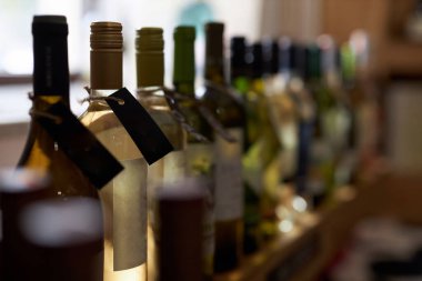 Beyaz şarap ve el işi etiketli şeffaf şişelerin orta derecede kapatılması