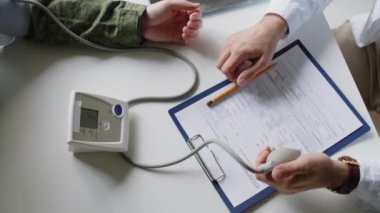 Tanınmayan bir doktorun ampul pompalarken, hastanedeki askeri üniformalı adama kan basıncı testi yaptığı en iyi görüntü.