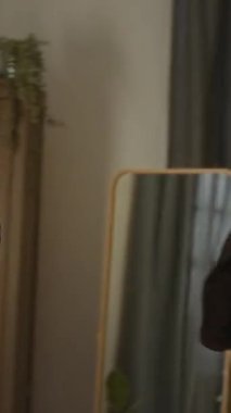 Sıcak yatak odasının dikey görüntüsü güneş ışığıyla yıkanmış, iki genç kız, gülümsüyor, bulaşıcı bir coşkuyla yatakta dans ediyor, elleri müzik ritmini neşeli hareketlerle taklit ediyor.