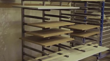 Mobilya atölyesinde ahşap panellerle endüstriyel kurutma rafından çekilen kimse yok.
