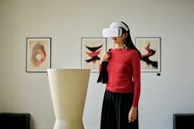 Çağdaş galeride duran bir kadın sanal gerçeklik kulaklığıyla etkileşime giriyor. Duvarlardaki minimalist sanat eserlerini gözlemlemek engin deneyimler yaratıyor
