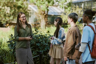 Genç bayan biyoloji öğretmeninin botanik bahçesindeki çocuklar için ortanca uzak plan çalışması.