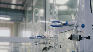 Modern beyaz laboratuarında bağlı tüpler ve mataralarla kimyasal teçhizatın yakın çekim eğiminde.