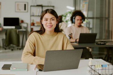 Bilgisayarda çalışan genç yetişkin ofislerinin orta boy yakın portresi.