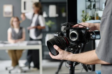 Çok büyük profesyonel lensleri tutan tanınmayan operatörlerin orta derecede yakın çekimi.