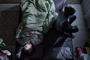 Çift ırklı bir çiftin yatakta üst üste çekimleri. Adam uykusuzluktan muzdaripken sevgili karısı rahat bir şekilde uyuyor.