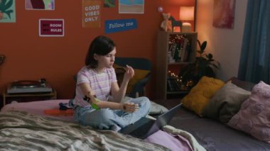 Geometri dersine hazırlanırken protez kullanan alfa kız rahat bir odada oturuyor.