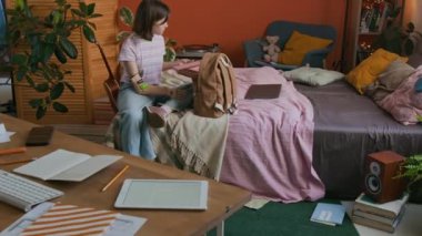 Kol protezli alfa kızı evde yatarken okul çantasını toplarken çek.