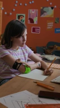 Tahta masadaki matematik sınavına hazırlanırken protezle kitap yazan genç bir kızın dikey görüntüsü