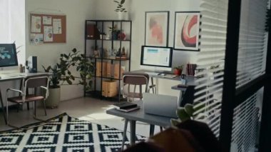 Üç çalışma istasyonu ve duvarlarında soyut sanat eserleri olan parlak minimalist çevre dostu ofis çekimleri yok.