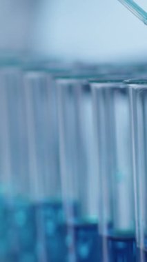 Dikey olarak hiç kimse mavi kimyasal çözeltinin pipetten tıp laboratuarında test tüplerine düştüğünü görmüyor.