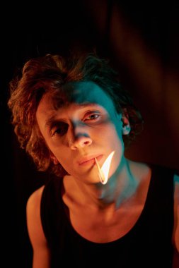 Depresyondan muzdarip genç bir adamın sigarayla zihinsel acıyı dindirmeye çalışmasının yüksek açılı görüntüsü.