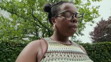 Siyah kadının gözlüğünü çıkarırken, laptopuyla uğraşırken, parkta bankta otururken kendini yorgun hissederken, elde çekilmiş bir zum.