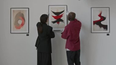 Profesyonel sanat küratörleri birlikte çalışıyor. Minimalist sanat galerisindeki diğer sanat eserlerinin yanına soyut tabloyu yerleştiriyorlar.