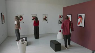 Minimalist sanat galerisindeki modern soyut resimlere hayran olan çok ırklı bir grup insanın zaman çizelgesi.