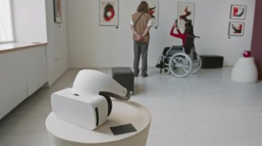 Sanat galerisindeki sergide duvarlardaki soyut kırmızı ve siyah sanat eserlerine hayran olan iki izleyicinin önünde VR kulaklığı el kamerası görüntüsüne yakınlaş