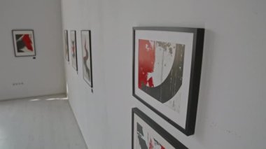 Hiçbir insan yüksek açılı, minimalist sanat galerisi duvarının birkaç çerçeveli kırmızı ve siyah soyut resimli yakın çekimini yapmaz.