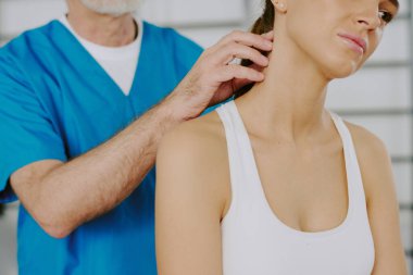 Uzman doktor bu bölgeyi incelerken orta derecede boyun omurgası ağrısından muzdarip bir kadın.