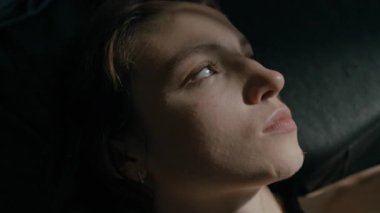 Kolundan çıkan gölgeli beyaz kadının yakın görüntüsü pencereden güneş ışığına doğru yöneldi, sonra gözlerini kapadı ve arkasını döndü.