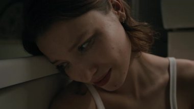 Gözlerinin altında maskara lekesi olan zavallı genç bir kadının banyoda yerde oturup ağladığı için yakın plan fotoğrafı.