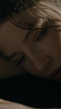 Stresli genç bir kadının telefonuna bakıp durduğu dikey yakın çekim. Kafası karışık ve konsantre olmakta zorlanıyor.