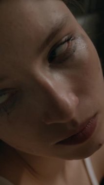 Maskarası bulaşmış perişan bir kızın dikey yakın çekimi. Hüsrana uğramış ve ağlıyor.