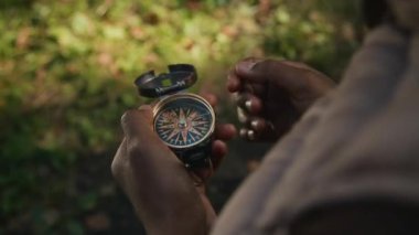 Aile yürüyüşü sırasında temel vahşi doğa becerilerini öğrenirken pusula ile gezen tanınamayan Afrikalı Amerikalı çocuğun yakın görüntüsü.