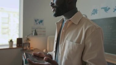 Modern okul sınıfında 3D modellik dersi verirken Afrika kökenli Amerikalı erkek öğretmenin hareketli çekimleri.