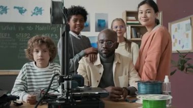 Modern 3D modellik sınıfında Afrikalı Amerikalı öğretmenlerin ve farklı yaşlardaki çocukların portre fotoğrafları.