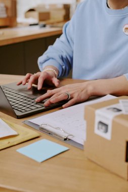 Düzenli ofis ortamında dizüstü bilgisayar üzerinde çalışan bireyler çalışma alanı etrafında çeşitli kağıtlar ve sabit olarak dikkat dağıtmadan verimli atmosfere katkıda bulunuyorlar.