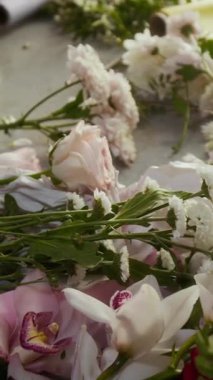 Çiçekçi masasında güllerden, kasımpatılardan ve orkidelerden vurulan hiç kimse çiçek aranjmanı yapmaya hazırlanmıyor.