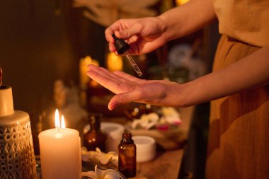 Avucunun içine serum atmak için elinde pipeti tutan tanınmayan bir kadın eli.