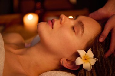 Kafasına masaj yaptıran, saçları dökülmüş genç bir kadının ideal profili.