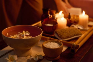 Orta boy seramik kase, saf su ve yüzen tesisat tomurcukları, deniz tuzu ile küçük ahşap kase.