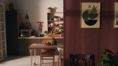 Kimse ön planda ve yemek salonunda masa, mutfak seti, ahşap raflar, soba, mikrodalga fırın ve buzdolabı olan iki modern sanat eserini göremez.