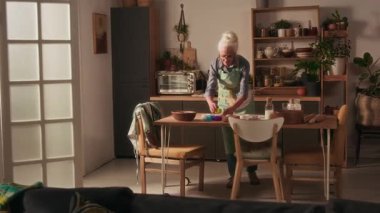 Mutfağa giren iki farklı çocuk yemek masasında her şeyi hazırlayan büyükannelerine sarılmak için koşuyorlar.