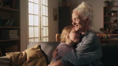 Kanepede birbirimize sarılırken gülümseyen torunumuzun sırtını nazikçe okşayan gözleri kapalı bir büyükanne.