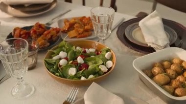 Taze salata, fırında patates, ızgara sebze ve yer ayarlarıyla yemek masası fotoğrafı çekilmeyecek.