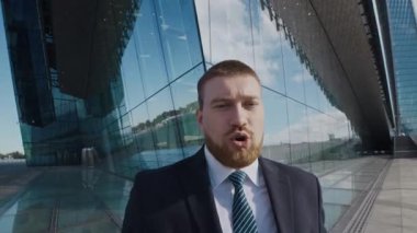 İş arkadaşlarıyla iş tartışan ve modern iş bölgesinde cam binalarla el sıkışan bir adam portresi.