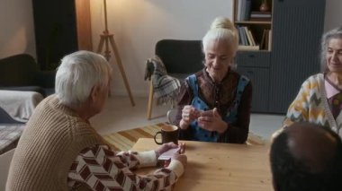 Yaşlı arkadaşlar ahşap masanın etrafında toplanmış iskambil oynuyorlardı. Huzurevinin rahat salonunda gülümsüyor ve konuşuyorlardı.