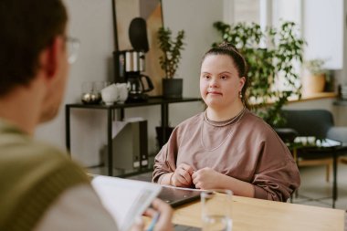 Down sendromlu kadın adayları test ederken kimliği belirsiz erkek mülakatçının omuz hizasında özgeçmiş tutması.
