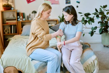 Anne, rahat ve iyi dekore edilmiş bir odada bir yatakta otururken protez kol takan genç kızıyla etkileşime giriyor.